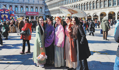 参加汉服巡游活动的意大利青年与现场观众（右一）合影。本报记者 谢亚宏摄