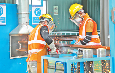 在马东铁项目铺轨基地，工人们正在焊接长钢轨。本报记者刘慧摄