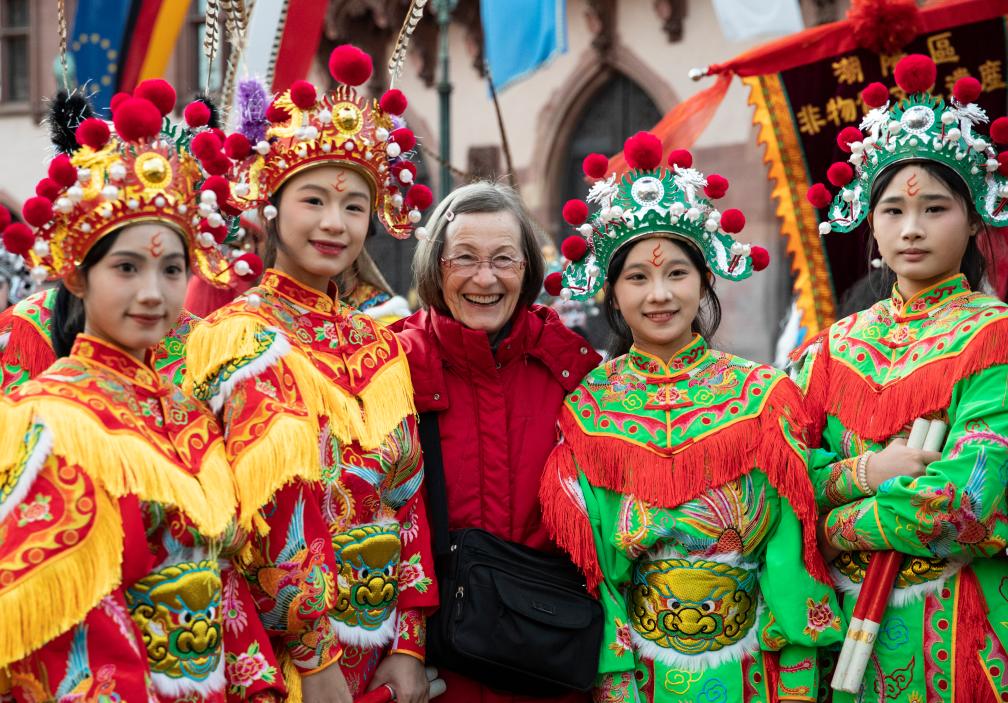 1月31日，在德国法兰克福，一名女子与潮汕英歌舞队演员在法兰克福市政厅前合影。新华社记者 张帆 摄