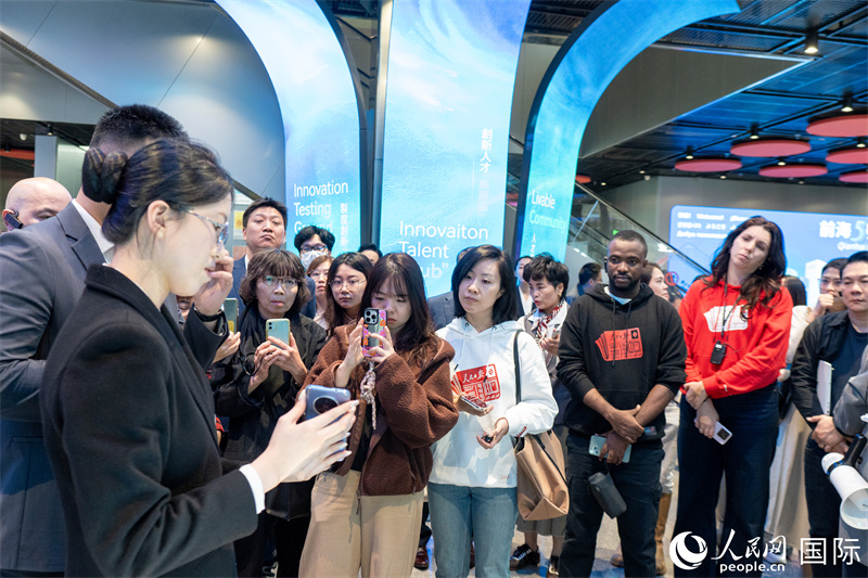 记者团在前海5号楼参观科技创新产品的展示并听取讲解。人民网记者 许峥摄