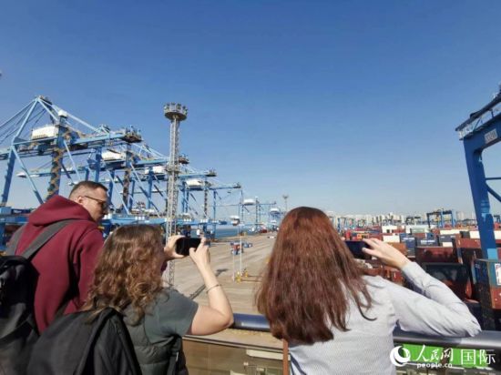 考察团成员拍摄青岛港全自动化集装箱码头。人民网记者 杨倩摄