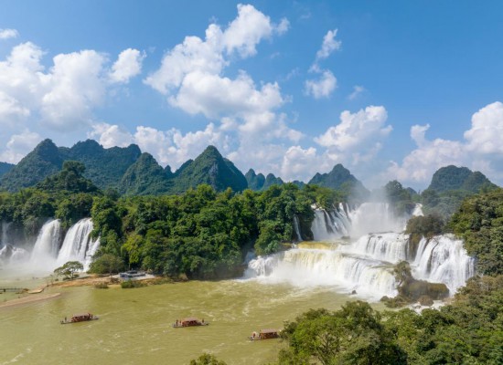 　　在广西崇左市大新县中越德天（板约）瀑布跨境旅游合作区，游人乘坐竹筏游览（无人机照片）。新华社发（龙涛摄）