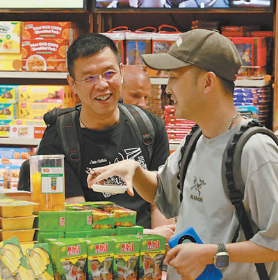 在泰国曼谷素万那普机场免税店，两名中国游客正在购买当地特色产品。本报记者 白元琪摄