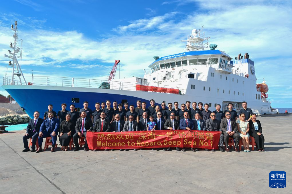 10月26日，应中国驻瑙鲁大使馆邀请，瑙鲁总统阿迪昂（前排中）、议长斯蒂芬（前排左七）等人登船参加开放日活动，并在瑙鲁艾沃港靠泊的“深海一号”船前与科考队员们合影。新华社记者 李鑫 摄